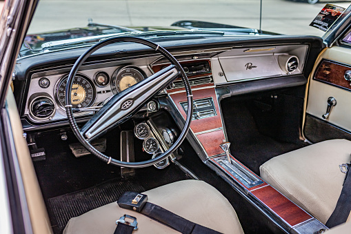 View through the driver window of a vintage convertible vehicle with a view of the steering wheel and dashboard