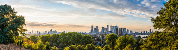 londoner skyline wahrzeichen und wolkenkratzer umrahmt von bäumen panorama - london england canary wharf skyline cityscape stock-fotos und bilder