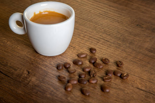 Coffee beans with a cup of espresso on wood table