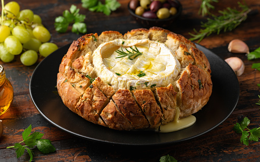Baked Camembert cheese in sourdough bread with rosemary, garlic, thyme.