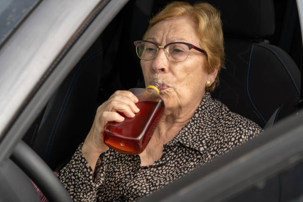 una anciana bebe un asiento de bebidas alcohólicas en un automóvil - conductor asignado fotografías e imágenes de stock