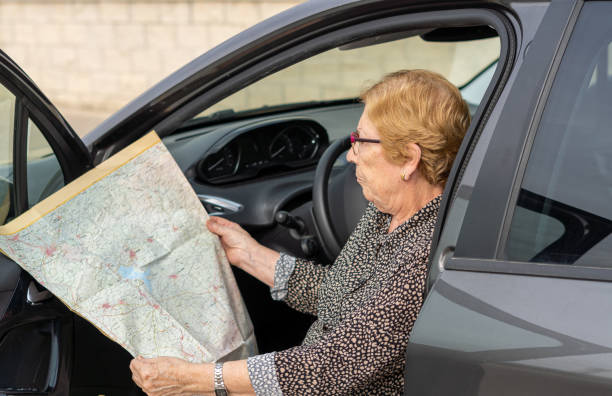 istock Senior woman searching direction inside car 1435905323