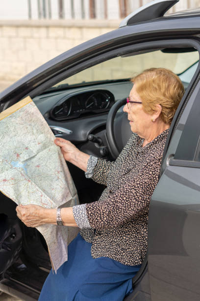 istock Senior woman searching direction inside car 1435905329