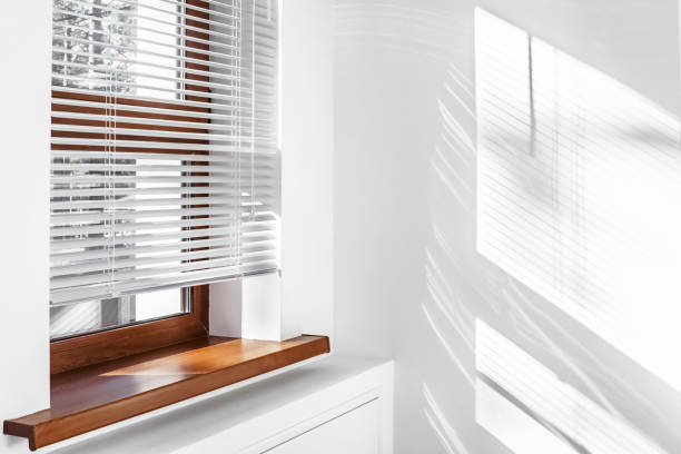 White Venetian blinds with sunlight and shadow. Window blinds. White Venetian blinds with sunlight and shadow. Window blinds. curtain call stock pictures, royalty-free photos & images
