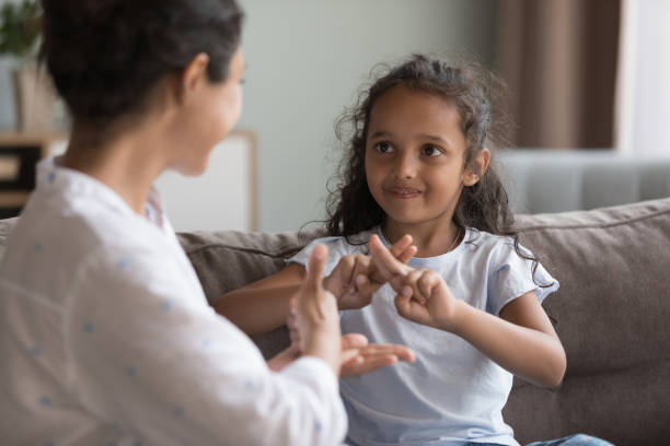 Deaf Indian girl and mother communicating using sign language stock photo