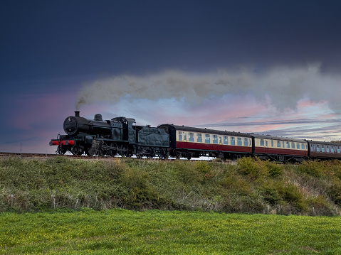 A steam train on a cold morning at sunrise