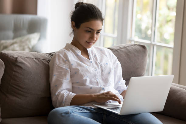 istock Attractive focused Indian woman using laptop at home 1435911398