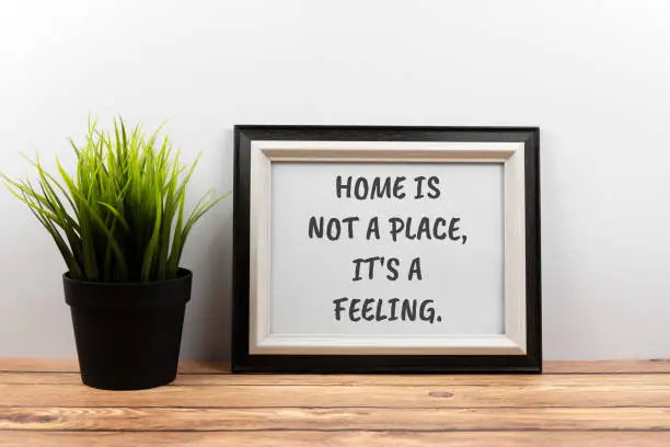 Photo of Inspirational quotes text in a frame - home is not a place, it's a feeling.