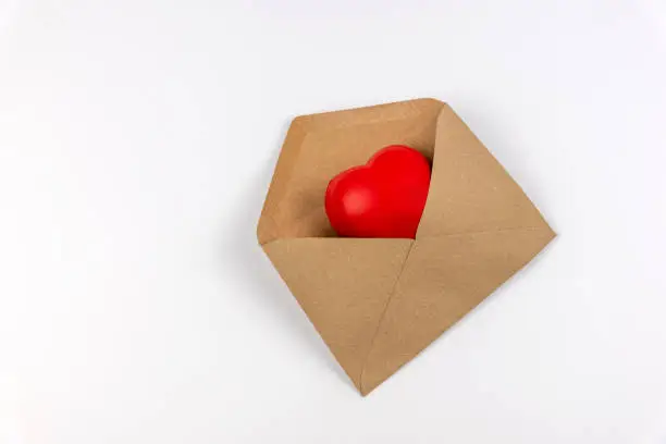 Photo of Heart shape in a brown envelope on white background