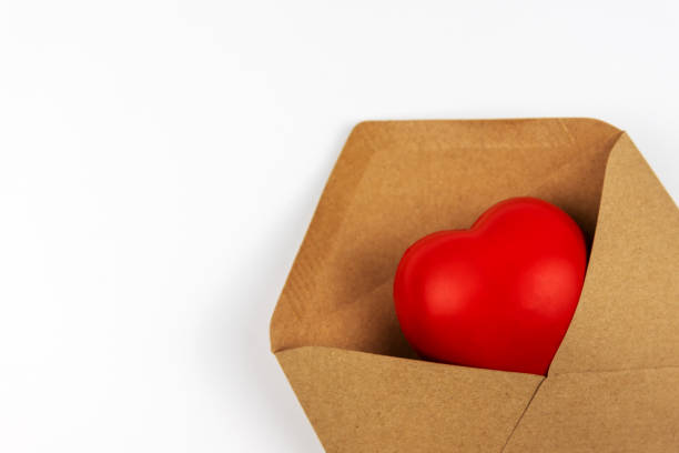 istock Close up of heart shape in a brown envelope on white background 1435913375
