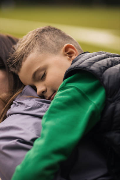 istock Tired young boy fell asleep on his mothers back 1435915104