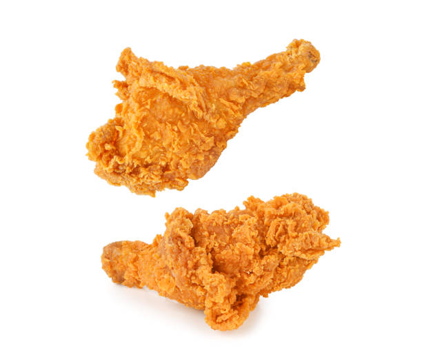 istock Fried chicken legs falling in the air isolated on white 1435917516