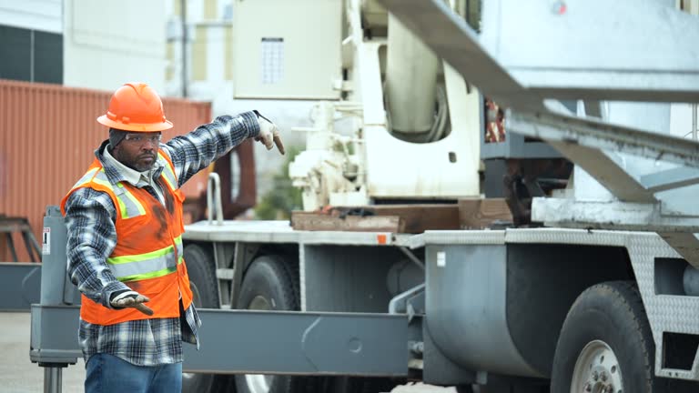 African-American man directing as crane lowers object