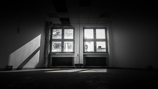in this abandoned office light falls through two old wooden windows