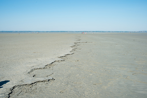 Sandy landscape during low tide. Crack that goes to the horizon. France