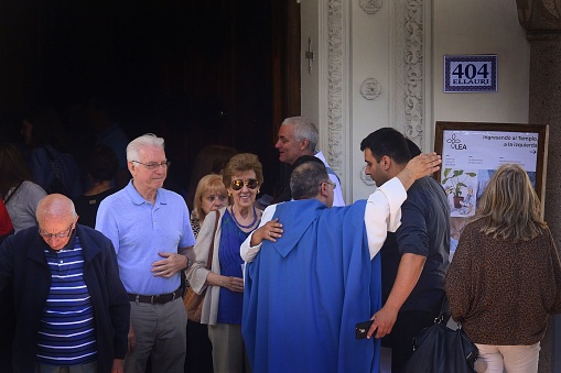 Montevideo, Uruguay – December 08, 2019: The priest interacts with parishioners as they leave the church