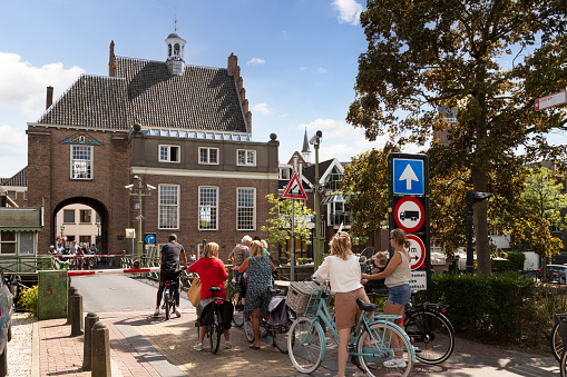 Montfoort, Netherlands, August 6, 2022; Cyclists wait until the bridge over the Hollandse Ijssel opens.