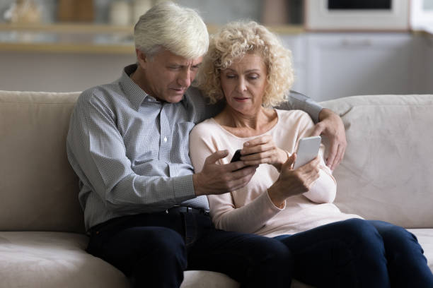 istock Elderly using two new bought modern smart phones at home 1435937737