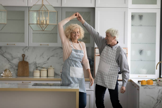 istock Happy lively older couple dancing in cozy kitchen 1435937885