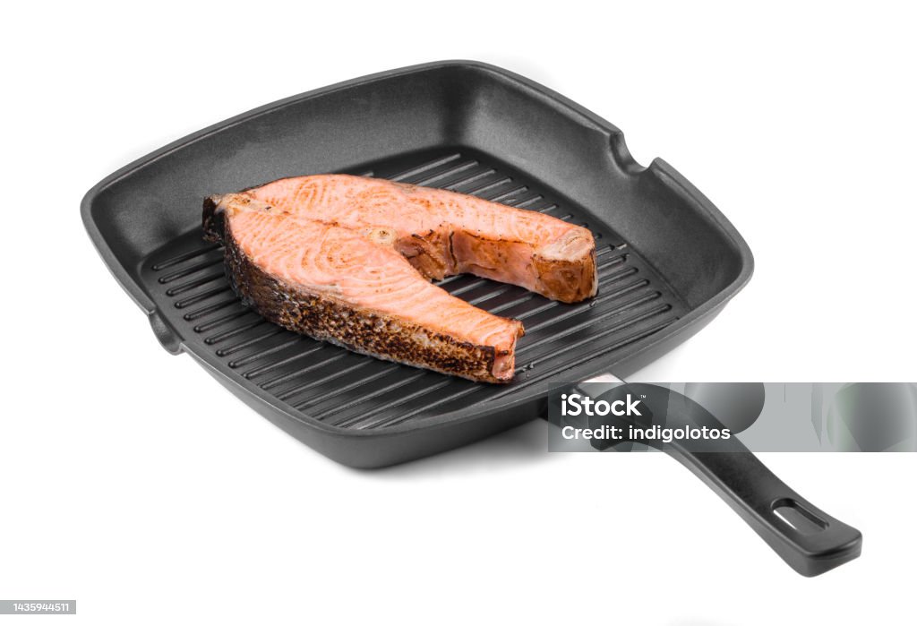 Frying pan with non-stick coating and salmon steak. Frying pan with non-stick coating and salmon steak. Isolated on a white background. Close-up. Baked Stock Photo