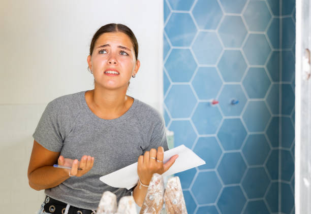 istock Frustrated young woman makes notes on paper in the bathroom 1435948985
