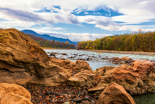 Landscape of a river with a fast current flowing in the foothills