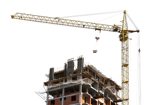 Tower crane and new building silhouettes under construction at construction site at white sky background