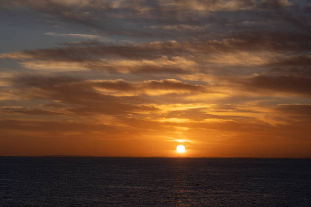 istock Dramatic sunrise and cloud formations over the sea near Dover, Southern England with a distant windmill farm sitting along the horizon line being illuminated by the rising sun 1435954175