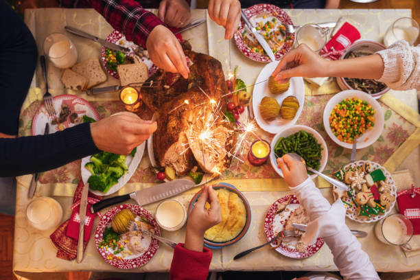 집에서 크리스마스를 축하하고 스파클러 불꽃 놀이를하는 가족 - christmas food dinner turkey 뉴스 사진 이미지