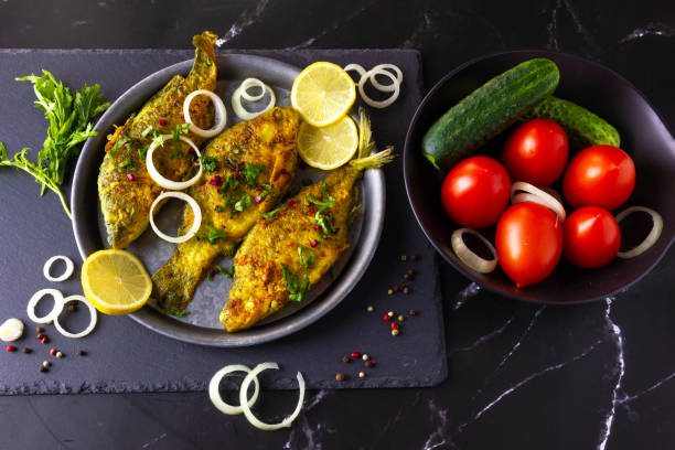 istock Fried Freshwater Fish with Lemon and Vegetables. 1435961792