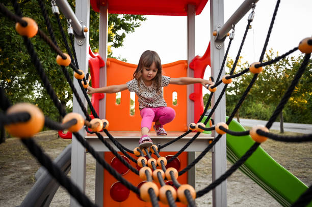 little toddler girl 3 years old in a playground climbing ropes skill,smiling,spider,spider web,sport,strength,summer,toddler,trampoline - equipment girl climbing ladder stock pictures, royalty-free photos & images