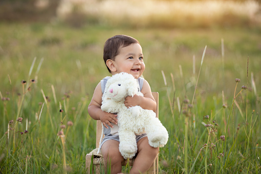 Cute one year-old latin american boy with teddy costume smiling outsoors - Sunset time - Buenos Aires Province - Argentina