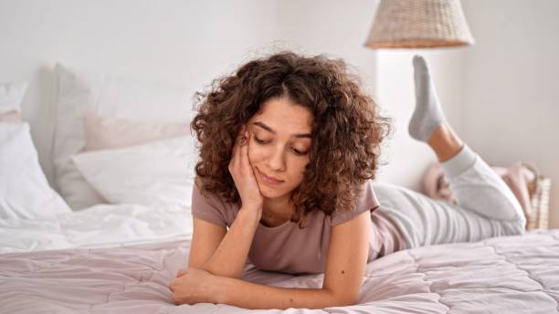 istock Young caucasian woman lying on her bed and thinking 1435977001