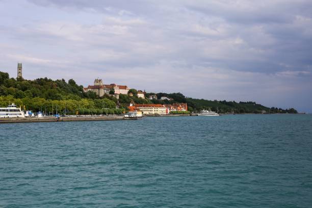 beautiful view of houses on a green coast by meersburg lake constance, germany under cloudy sky - seepromenade imagens e fotografias de stock