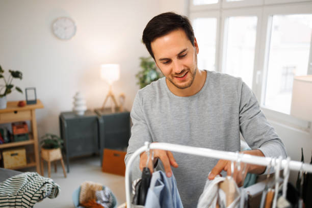istock Man selecting clothes from rack at home 1435987088