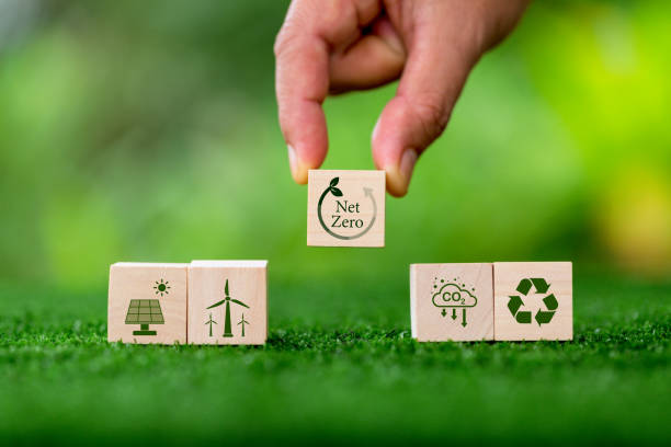 istock Net zero and carbon neutral concept. Net zero greenhouse gas emissions target. Climate neutral long term strategy. Wooden cubes with green net zero icon and green conserve icon on nature background. 1435987159