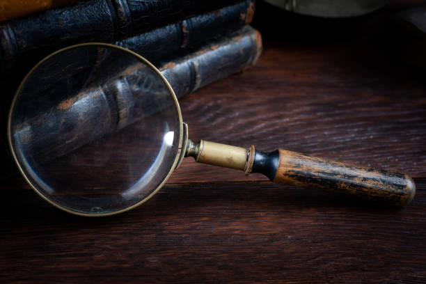 istock Old vintage magnifying glass with books on woden table 1435989159