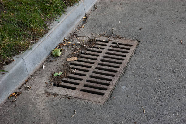 istock Rusty storm drain grate on the road next to the lawn 1435989421