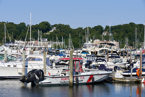 Halesite, NY USA - Aug 19, 2022: Boats in the Mill Dam Marina including the Huntington Fire Department launch. The marina is owned by the Town of Huntington and located in Huntington Harbor with boat slips and boat launching ramps