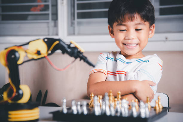 istock Asian little boy is playing chess with robot machine arm 1435996358