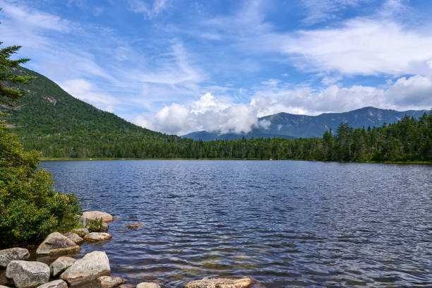 Lonesome Lake is a pristine glacial lake in Franconia Notch State Park in Franconia, NH Lonesome Lake is a pristine glacial lake in Franconia Notch State Park in the White Mountains of NH, in Franconia, NH on a summer day with blue sky and dramatic clouds. franconia new hampshire stock pictures, royalty-free photos & images