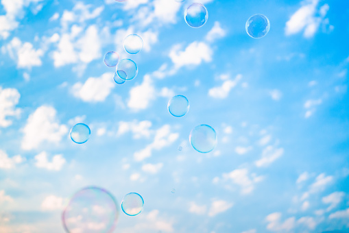 Bubbles floating in the air, blue sky and white clouds