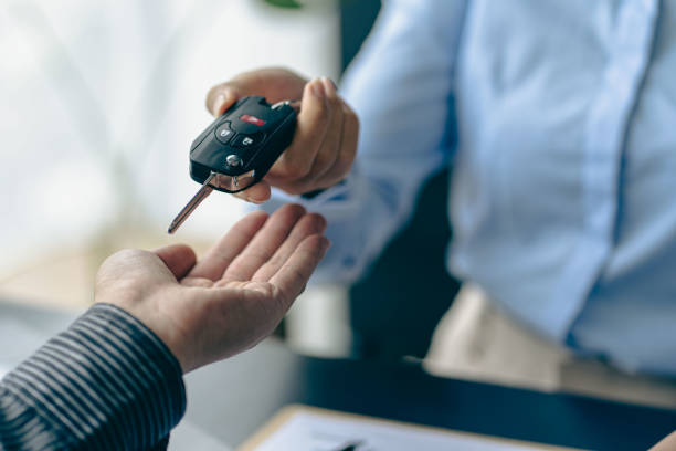 del representante guarde las llaves del automóvil al nuevo propietario después de firmar el contrato de arrendamiento en el documento del contrato de venta del automóvil. - alquiler de coche fotografías e imágenes de stock