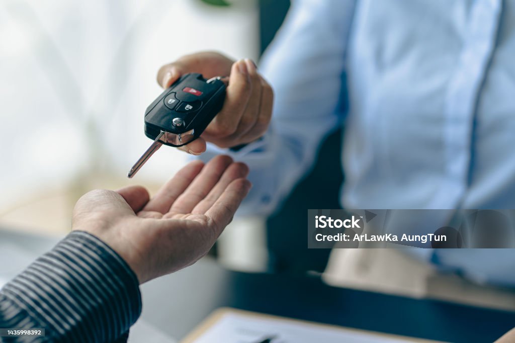 of the representative Hold the car keys to the new owner after signing the leasing contract in the car sales contract document. Car Rental Stock Photo