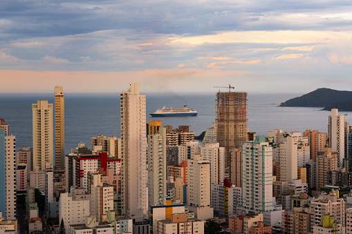 Balneário Camboriú, Santa Catarina, Brazil - January 3, 2019: Moment when the cruise ship appears aligned with the buildings of the waterfront of Balneário due to the perspective