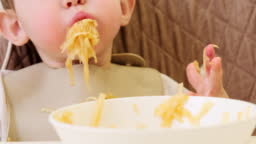 A Funny Child Is Eating A Grated Apple With His Mouth Full While Sitting On A Kitchen Chair Hungry Baby Boy Shoves Food In His Mouth Humor Stock Video - Download Video A Funny Child Is Eating A Grated Apple With His Mouth Full While Sitting On A Kitchen Chair Hungry Baby Boy Shoves Food In His Mouth Humor Stock Video - Download Video