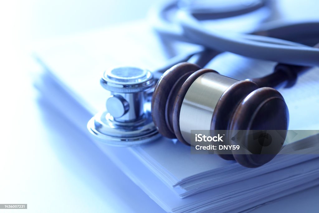 Gavel And Stethoscope A gavel and a stethoscope on top of a stack of documents. Photographed with a very shallow depth of field. Healthcare And Medicine Stock Photo