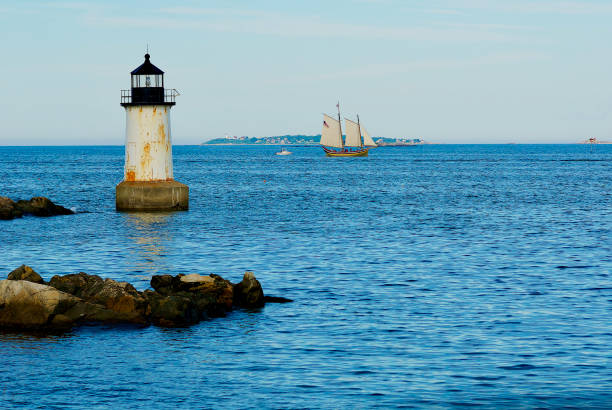 Salem, Massachusetts, USA - June 24, 2019: The Fort Pickering Lighthouse stands out in evening sunlight at the entrance to Salem Harbor on a summer evening.