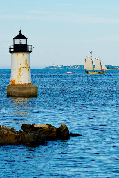 Salem, Massachusetts, USA - June 24, 2019: The Fort Pickering Lighthouse stands out in evening sunlight at the entrance to Salem Harbor on a summer evening.