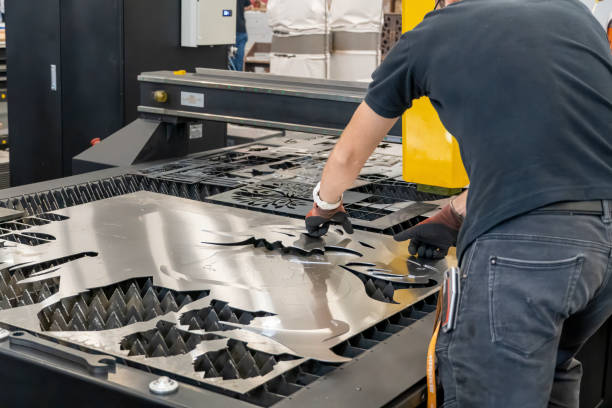 laser cutting machine, cutting wood sheets, while a man takes care of the process, latin america laser cutting machine, cutting wood sheets, while a man takes care of the process, mexico latin america laser cutting metal stock pictures, royalty-free photos & images